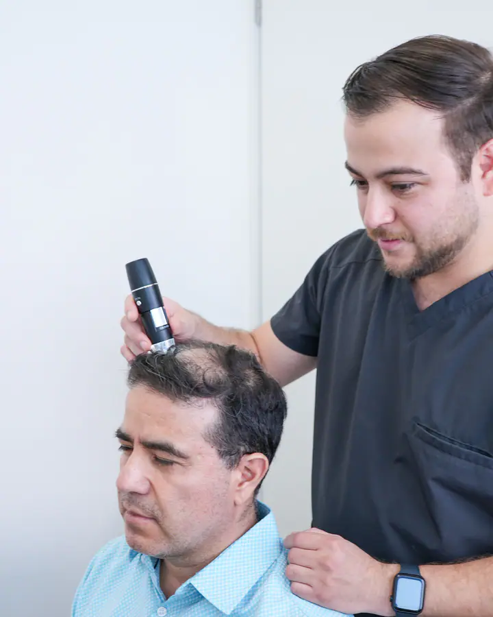 Diagnóstico con tricoscopio del cuero cabelludo de un paciente con caída del cabello